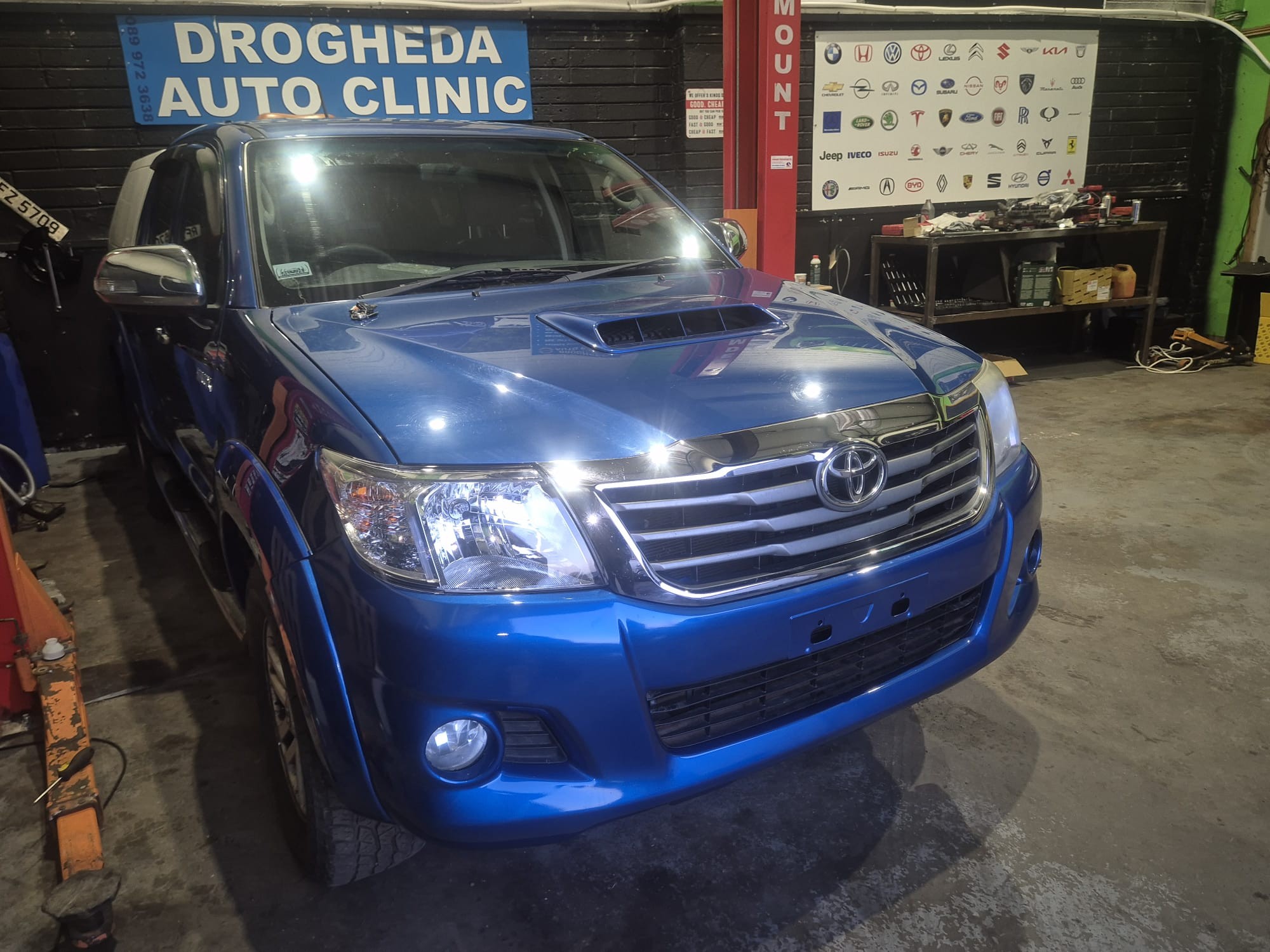 Toyota Hilux in workshop with brand board