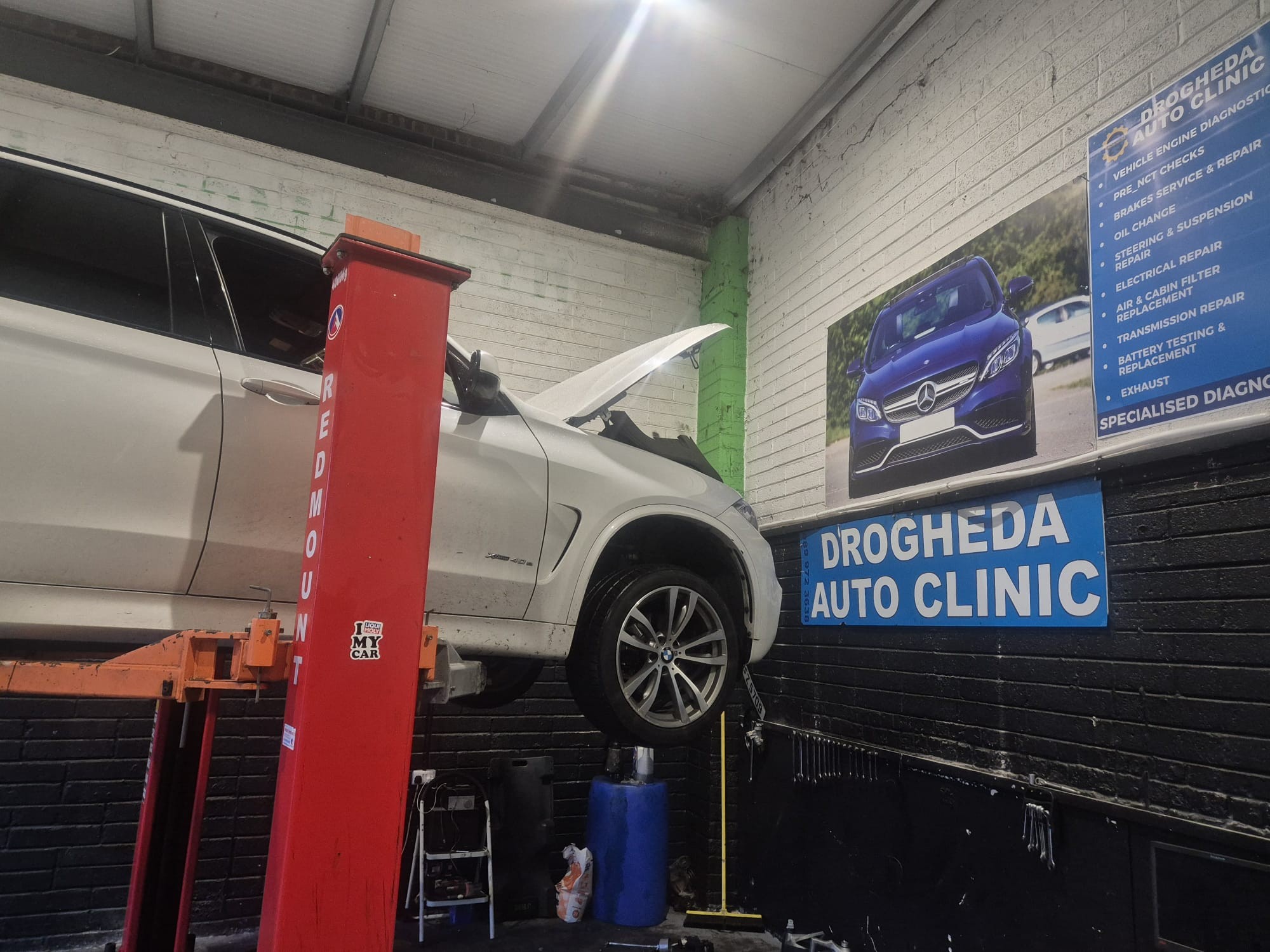 BMW X5 on lift with services board