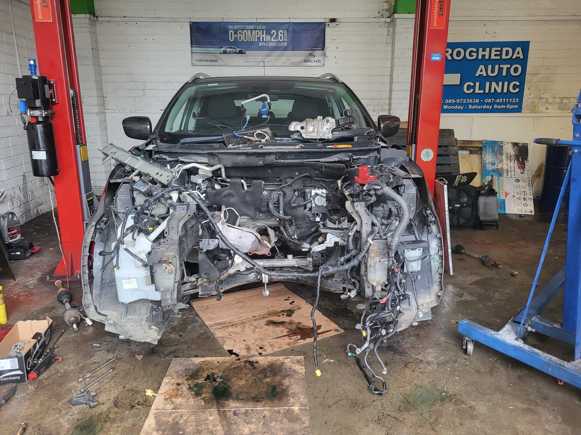 SUV mid-repair on lift at Drogheda Auto Clinic